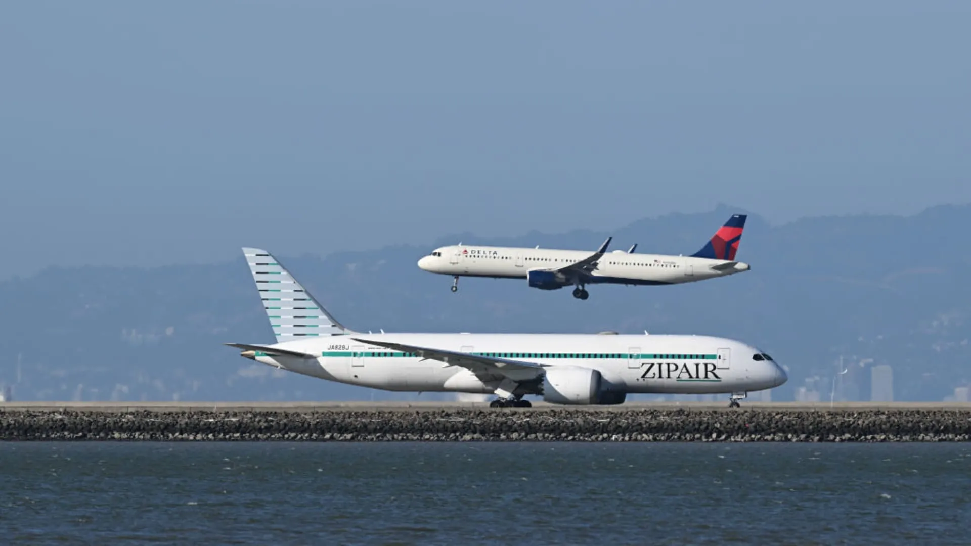 Budget airline aircraft parked on tarmac at Asian airport terminal