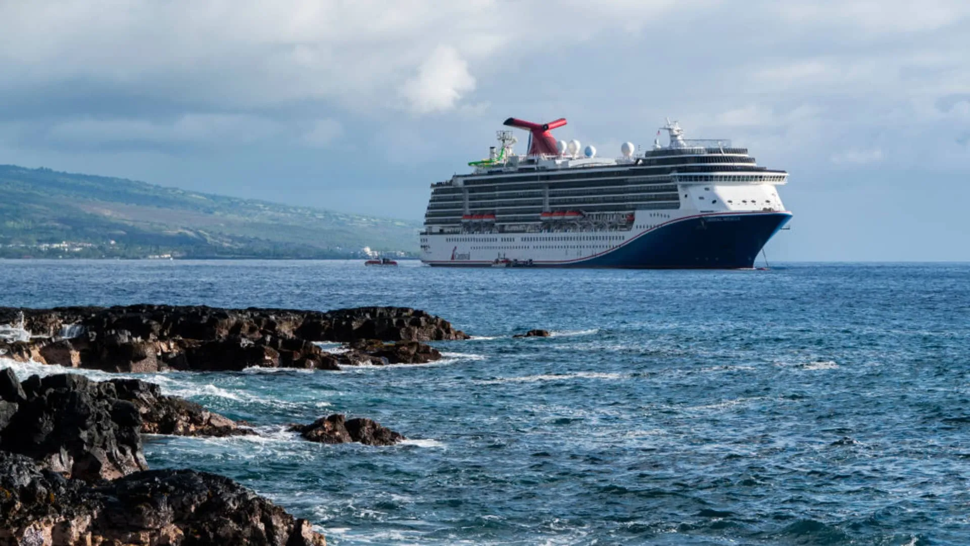 Cruise ship sailing through ocean waters near coastline